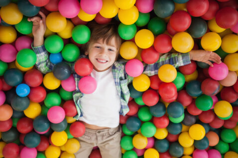 Cute boy smiling in ball pool at a party
